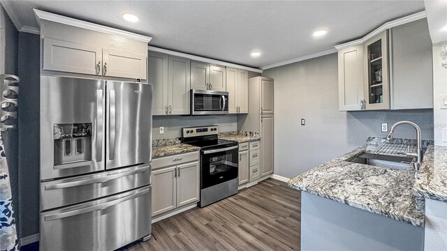 4218 Drexel Ave, Orlando, FL 32808 - kitchen with appliances with stainless steel finishes, light stone counters, crown molding, glass insert cabinets, and dark wood finished floors