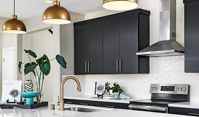 kitchen featuring dark cabinets, electric range, and wall chimney range hood