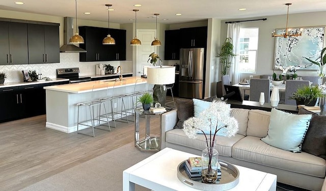 living room with recessed lighting, a chandelier, and light wood finished floors