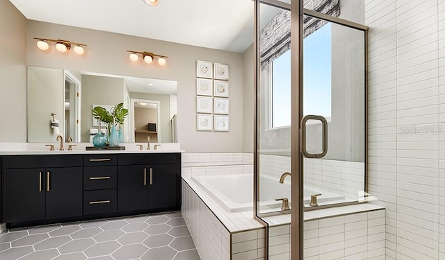 full bathroom featuring tile patterned floors, a bath, double vanity, and a shower stall