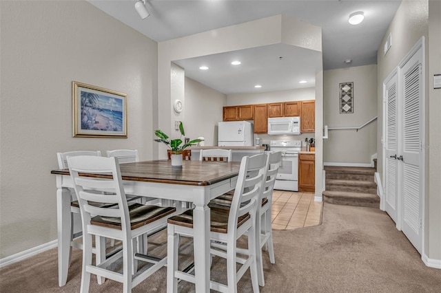 2614 Lodi Cir Unit 106, Kissimmee, FL 34746 - dining space with light colored carpet, recessed lighting, baseboards, and stairway