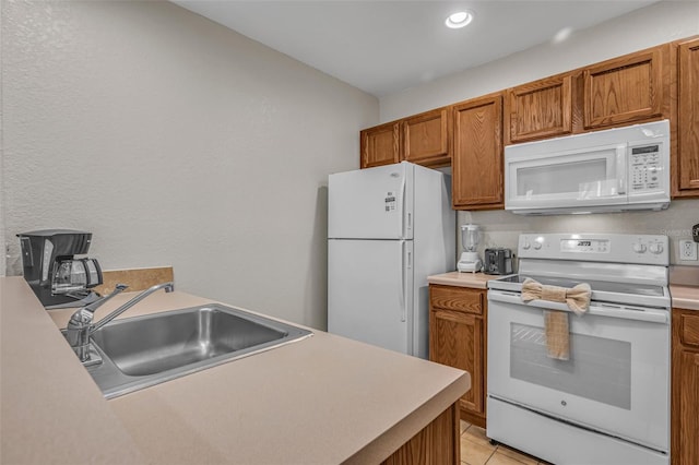2614 Lodi Cir Unit 106, Kissimmee, FL 34746 - kitchen featuring white appliances, a sink, brown cabinetry, light countertops, and light tile patterned flooring