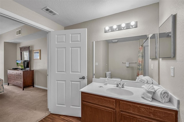 2614 Lodi Cir Unit 106, Kissimmee, FL 34746 - bathroom with toilet, a shower with curtain, a textured ceiling, vanity, and a textured wall