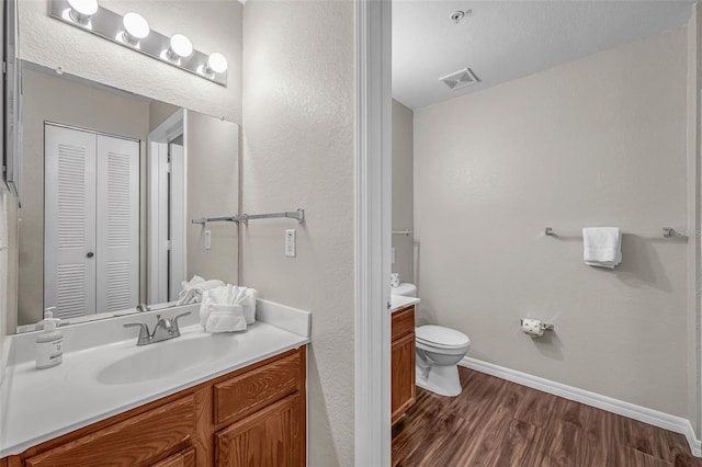 2614 Lodi Cir Unit 106, Kissimmee, FL 34746 - bathroom with vanity, wood finished floors, a closet, toilet, and baseboards