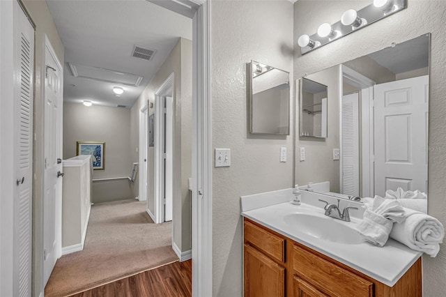 2614 Lodi Cir Unit 106, Kissimmee, FL 34746 - bathroom featuring wood finished floors, a textured wall, vanity, a closet, and baseboards