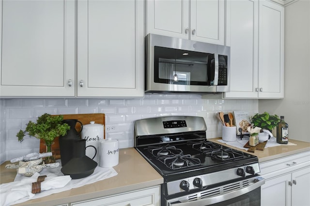 kitchen with appliances with stainless steel finishes, white cabinets, light countertops, and decorative backsplash