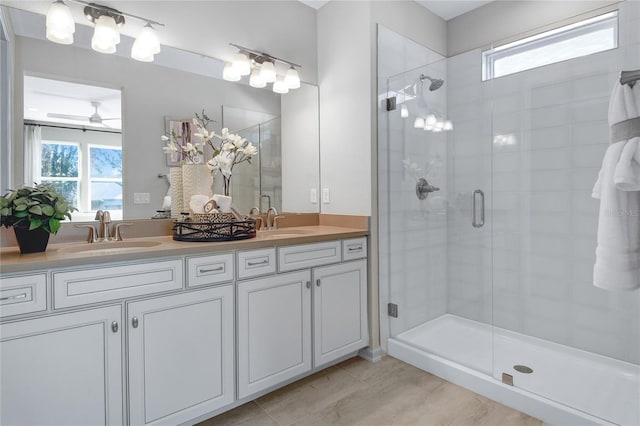 bathroom featuring healthy amount of natural light, a stall shower, and double vanity