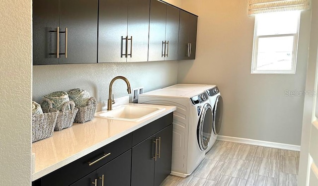 laundry room featuring cabinet space, washer and clothes dryer, and baseboards