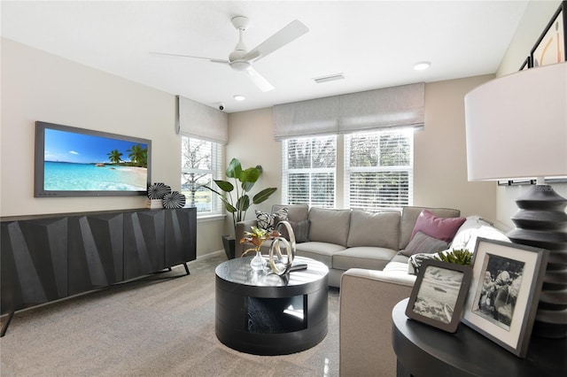 carpeted living area featuring a ceiling fan and baseboards