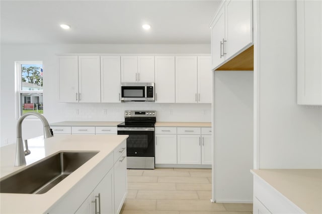 3723 Malad Way, Tavares, FL 32778 - kitchen featuring appliances with stainless steel finishes, white cabinetry, tasteful backsplash, recessed lighting, and light countertops