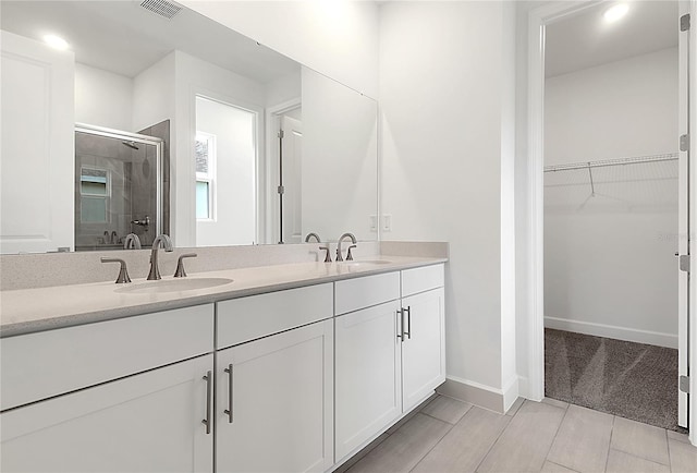 3723 Malad Way, Tavares, FL 32778 - bathroom with a shower stall, double vanity, a walk in closet, and recessed lighting