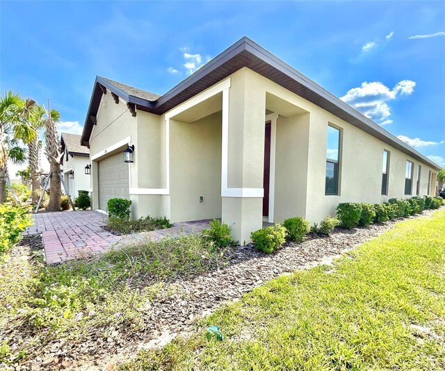 1001 Umbria Dr, Poinciana, FL 34759 - view of side of home with stucco siding and a garage