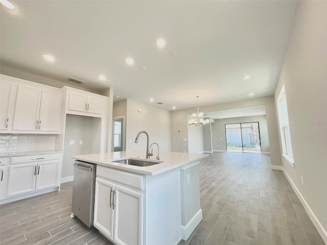 1001 Umbria Dr, Poinciana, FL 34759 - kitchen with light wood-style floors, a chandelier, stainless steel dishwasher, white cabinetry, and recessed lighting