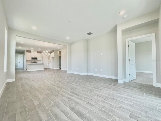 1001 Umbria Dr, Poinciana, FL 34759 - unfurnished living room featuring a chandelier, recessed lighting, and light wood finished floors