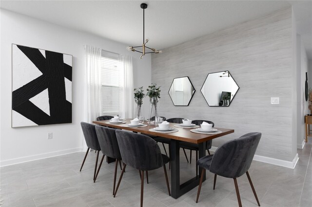 4290 Paragraph Dr, Kissimmee, FL 34746 - dining room with a chandelier, baseboards, an accent wall, and light tile patterned floors