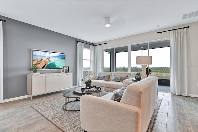 9253 Players Dr, Weeki Wachee, FL 34613 - living room with light wood finished floors, a ceiling fan, and baseboards