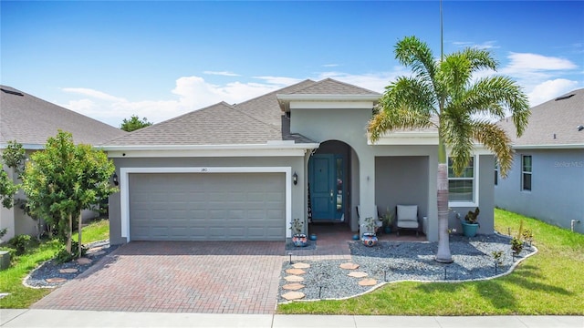 140 Trinity Ridge Cir, Davenport, FL 33897 - view of front of home with stucco siding, an attached garage, decorative driveway, and a shingled roof