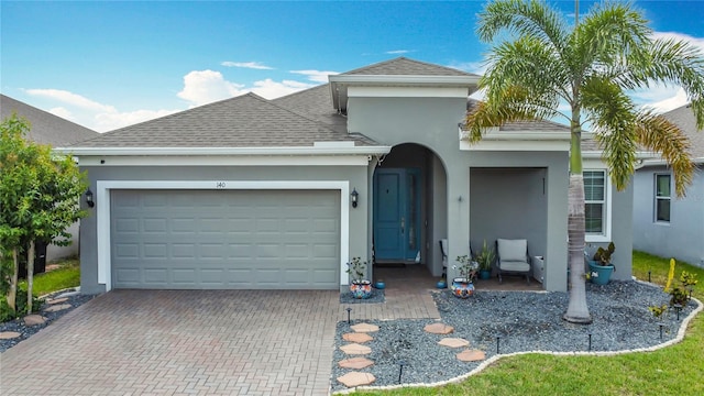 140 Trinity Ridge Cir, Davenport, FL 33897 - view of front of house featuring stucco siding, an attached garage, decorative driveway, and roof with shingles