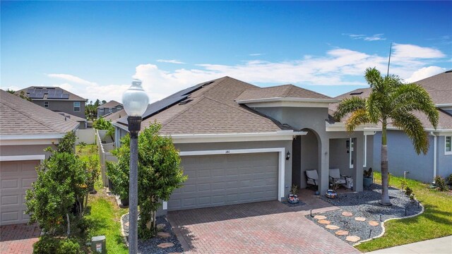 140 Trinity Ridge Cir, Davenport, FL 33897 - view of front of home with stucco siding, an attached garage, decorative driveway, and a shingled roof