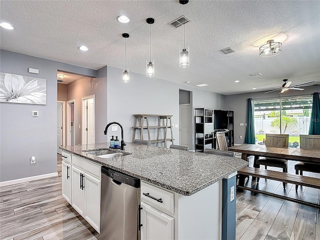 140 Trinity Ridge Cir, Davenport, FL 33897 - kitchen with dishwasher, a sink, light wood-style flooring, a textured ceiling, and ceiling fan