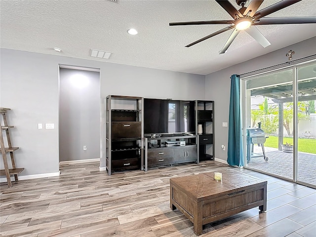 140 Trinity Ridge Cir, Davenport, FL 33897 - living room featuring ceiling fan, a textured ceiling, wood finished floors, and baseboards
