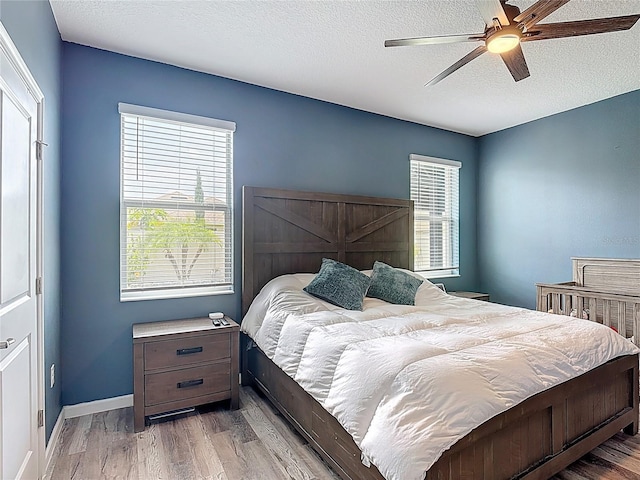 140 Trinity Ridge Cir, Davenport, FL 33897 - bedroom featuring a textured ceiling, wood finished floors, a ceiling fan, and baseboards