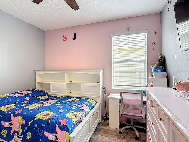 140 Trinity Ridge Cir, Davenport, FL 33897 - bedroom with wood finished floors, multiple windows, a textured ceiling, a ceiling fan, and a desk