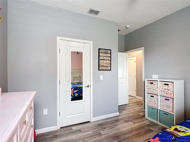 140 Trinity Ridge Cir, Davenport, FL 33897 - bedroom with wood finished floors, baseboards, a textured ceiling, and a closet
