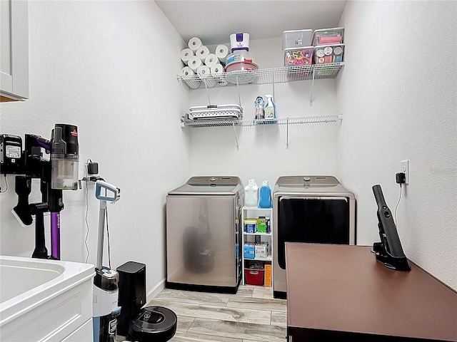 140 Trinity Ridge Cir, Davenport, FL 33897 - laundry area featuring washer and dryer, cabinet space, light wood-style floors, and baseboards