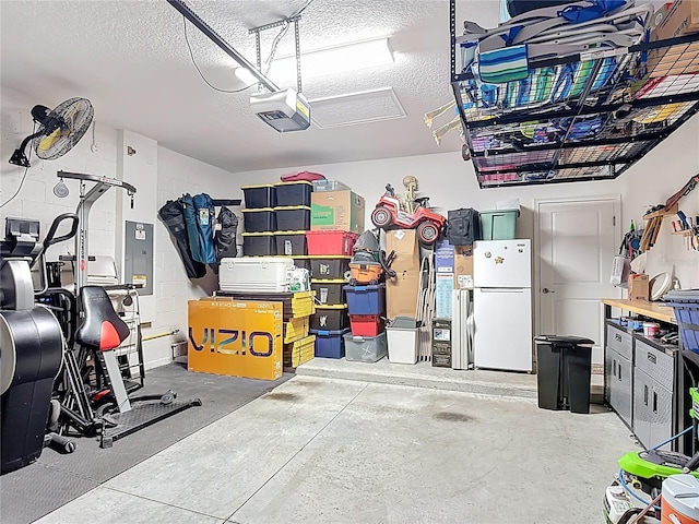 140 Trinity Ridge Cir, Davenport, FL 33897 - garage featuring freestanding refrigerator, electric panel, and a garage door opener