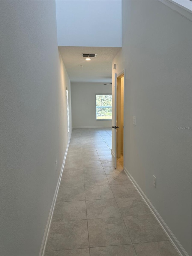 hall with light tile patterned floors and baseboards