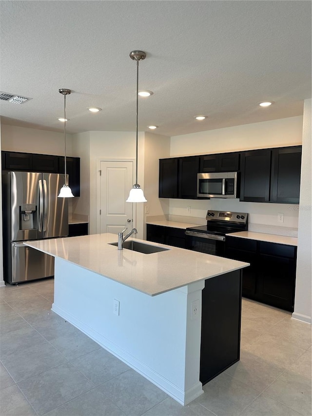 kitchen featuring stainless steel appliances, dark cabinets, a sink, light countertops, and recessed lighting