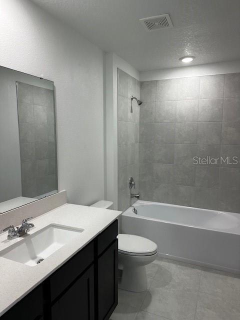 bathroom featuring washtub / shower combination, toilet, and vanity