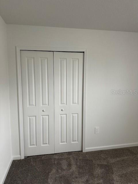 unfurnished bedroom with carpet flooring and baseboards