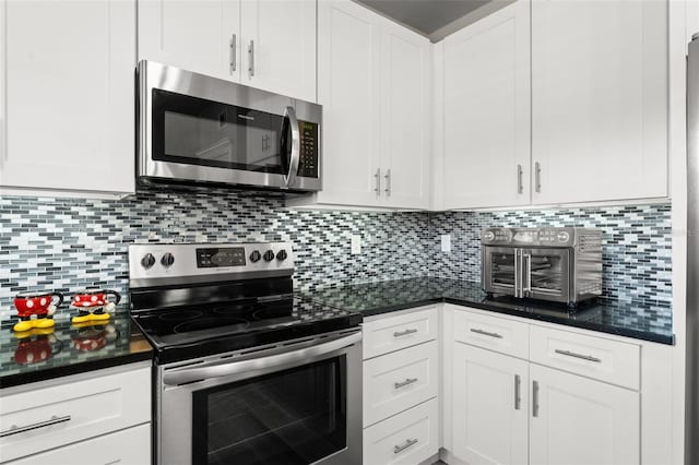 438 Water St Unit 438, Celebration, FL 34747 - kitchen featuring stainless steel appliances, dark countertops, white cabinetry, and backsplash