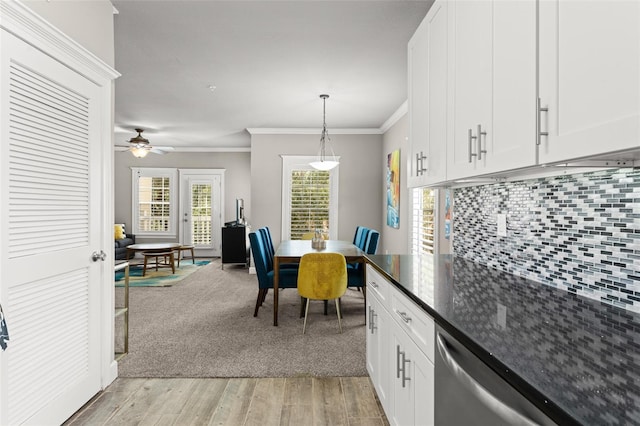 438 Water St Unit 438, Celebration, FL 34747 - kitchen with stainless steel dishwasher, white cabinetry, light wood finished floors, ornamental molding, and decorative light fixtures
