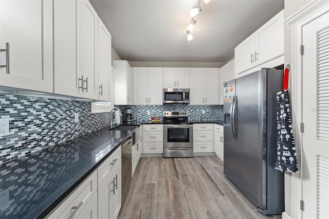 438 Water St Unit 438, Celebration, FL 34747 - kitchen featuring stainless steel appliances, light wood-style flooring, white cabinetry, and decorative backsplash