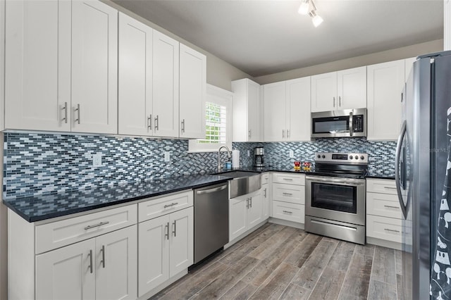 438 Water St Unit 438, Celebration, FL 34747 - kitchen with stainless steel appliances, wood finished floors, white cabinetry, and backsplash