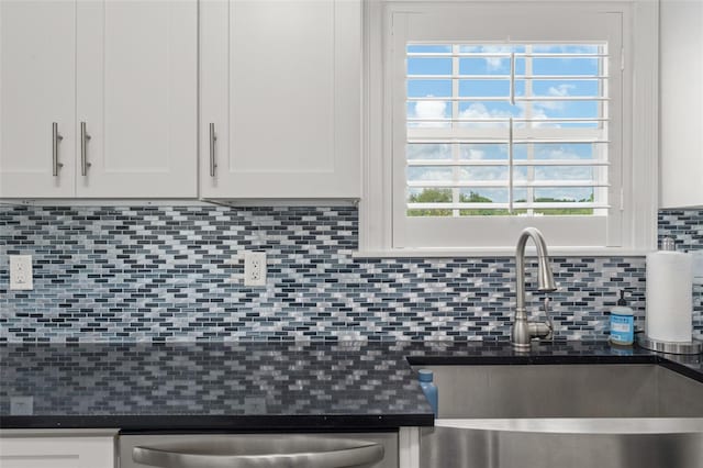 438 Water St Unit 438, Celebration, FL 34747 - kitchen featuring dark countertops, white cabinetry, and backsplash