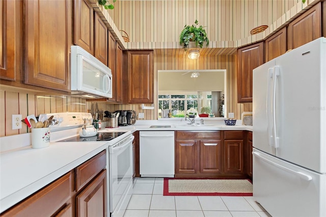 124 Ashton Dr, Davenport, FL 33837 - kitchen with white appliances, a sink, light tile patterned flooring, light countertops, and brown cabinetry
