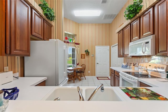 124 Ashton Dr, Davenport, FL 33837 - kitchen featuring white appliances, light countertops, a sink, and brown cabinets
