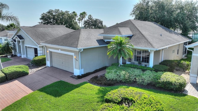 124 Ashton Dr, Davenport, FL 33837 - view of front facade with a garage, stucco siding, driveway, and a shingled roof