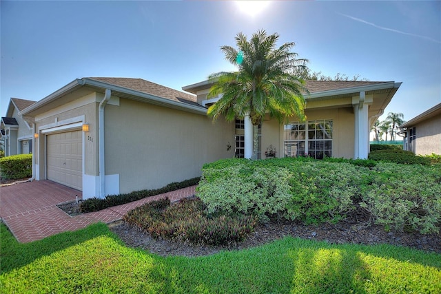 124 Ashton Dr, Davenport, FL 33837 - ranch-style house featuring an attached garage, stucco siding, and decorative driveway