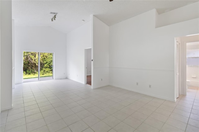 3370 Cypress Point Cir, Saint Cloud, FL 34772 - empty room featuring light tile patterned floors, high vaulted ceiling, and baseboards