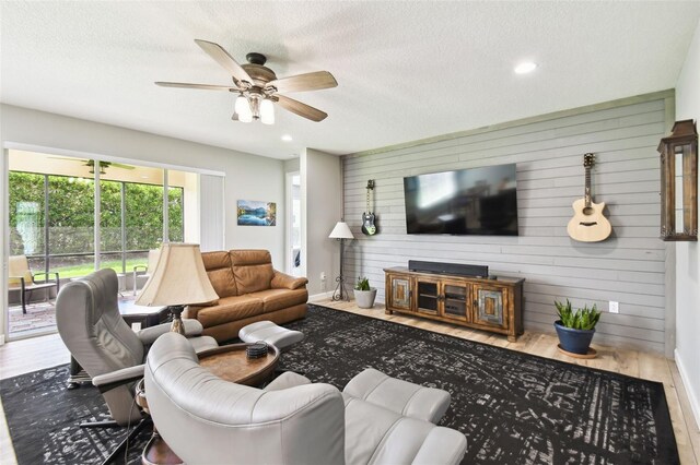 1272 Bonita Canyon Dr, Kissimmee, FL 34759 - living area featuring wood finished floors, wooden walls, a ceiling fan, baseboards, and a textured ceiling