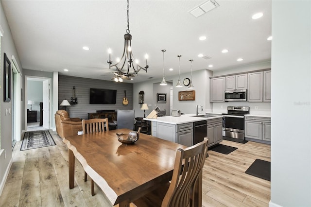 1272 Bonita Canyon Dr, Kissimmee, FL 34759 - dining area with a chandelier, recessed lighting, light wood-style floors, an accent wall, and baseboards