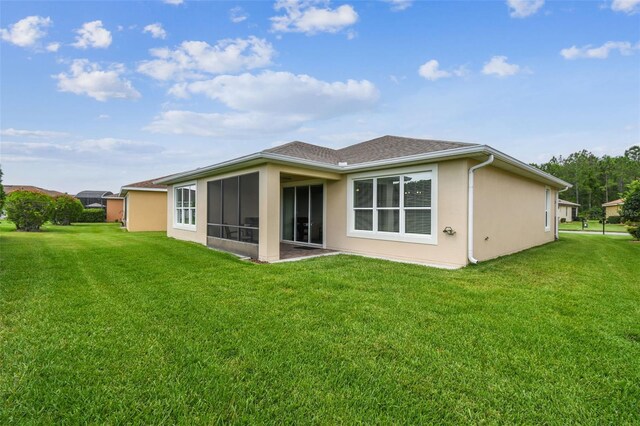 1272 Bonita Canyon Dr, Kissimmee, FL 34759 - rear view of house featuring a yard, stucco siding, and a sunroom