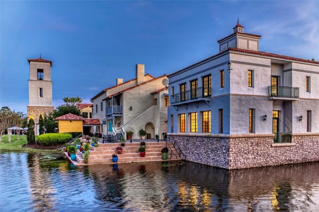 1272 Bonita Canyon Dr, Kissimmee, FL 34759 - back of property featuring a balcony, a water view, a chimney, and stairway