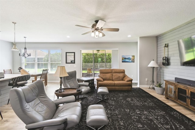 1272 Bonita Canyon Dr, Kissimmee, FL 34759 - living area featuring wood walls, wood finished floors, a ceiling fan, baseboards, and a chandelier