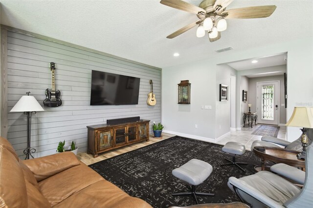 1272 Bonita Canyon Dr, Kissimmee, FL 34759 - living room with wooden walls, baseboards, a ceiling fan, recessed lighting, and a textured ceiling